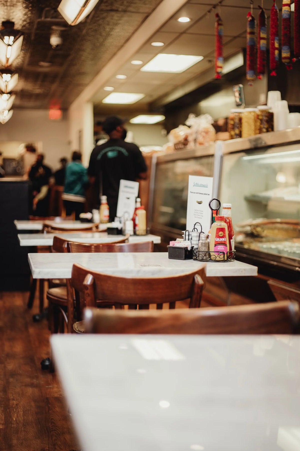 Diner interior with tables, chairs, and a counter with condiments.