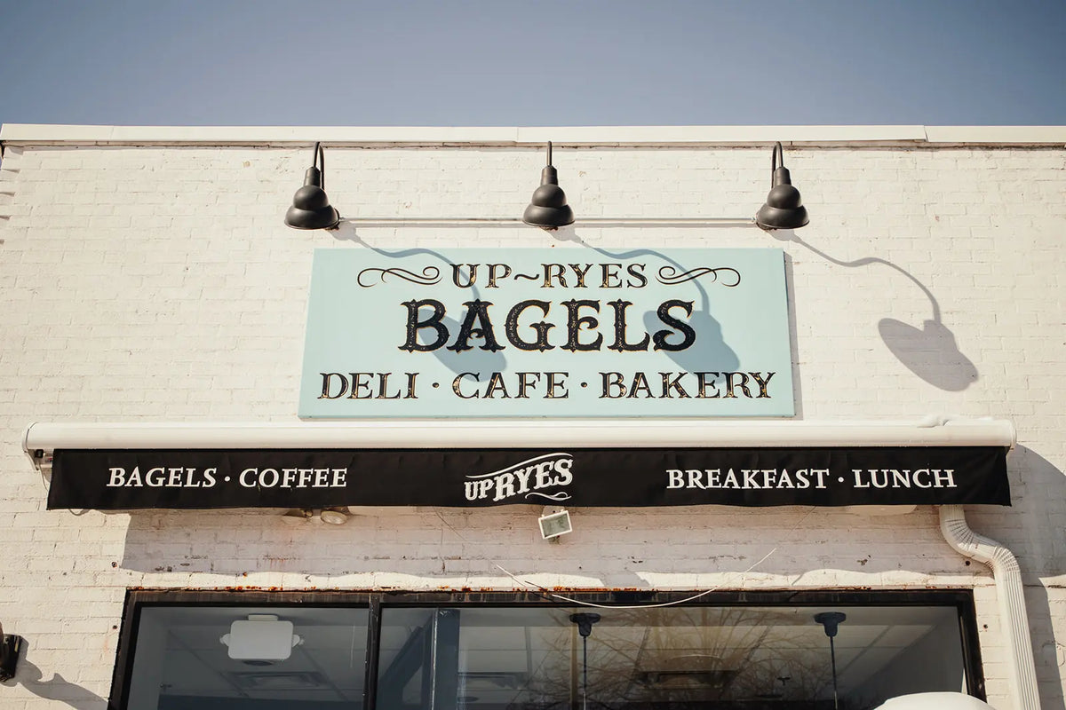 Up-Ryess Bagels deli, cafe, and bakery sign on a building facade.