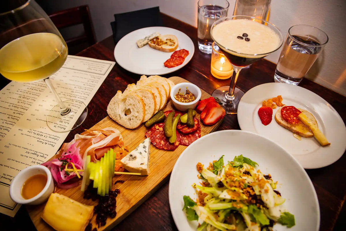 Dinner table with plates of food, drinks, and a menu
