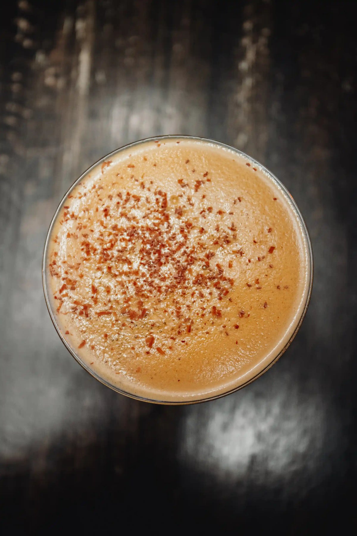 Bean2Bean Espresso Martini with cinnamon sprinkles in a glass on a dark background