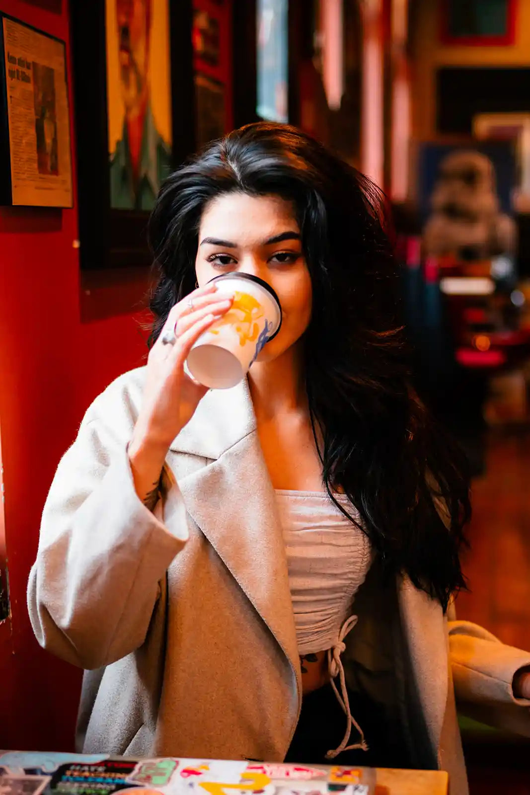 Woman drinking from a coffee cup in a cozy indoor setting
