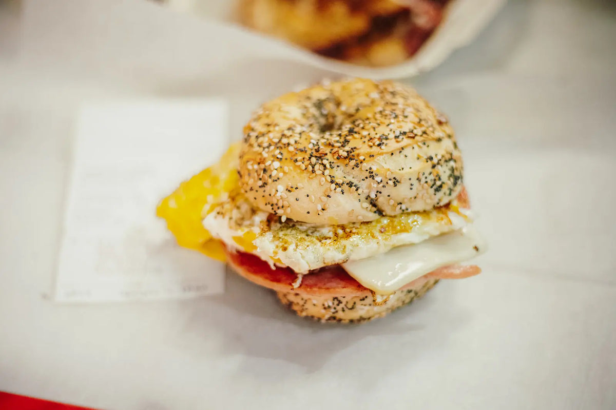 Bagel sandwich with egg and cheese on a white surface
