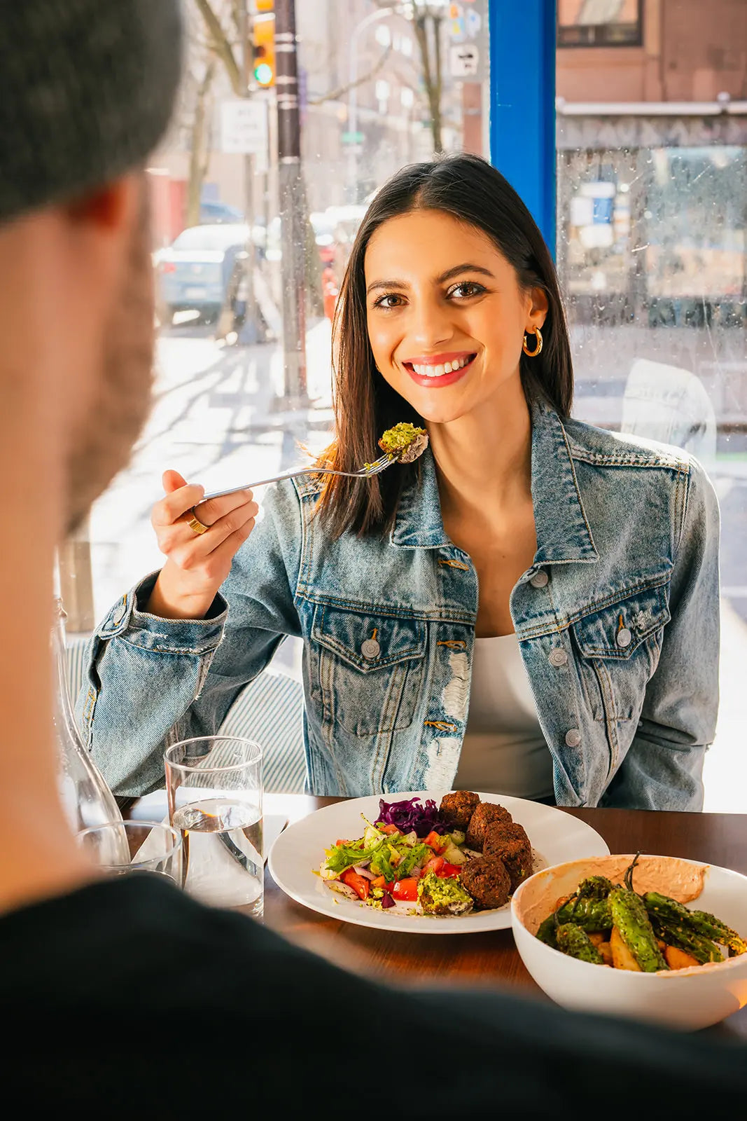 Woman enjoying a meal with a man in an outdoor cafe setting