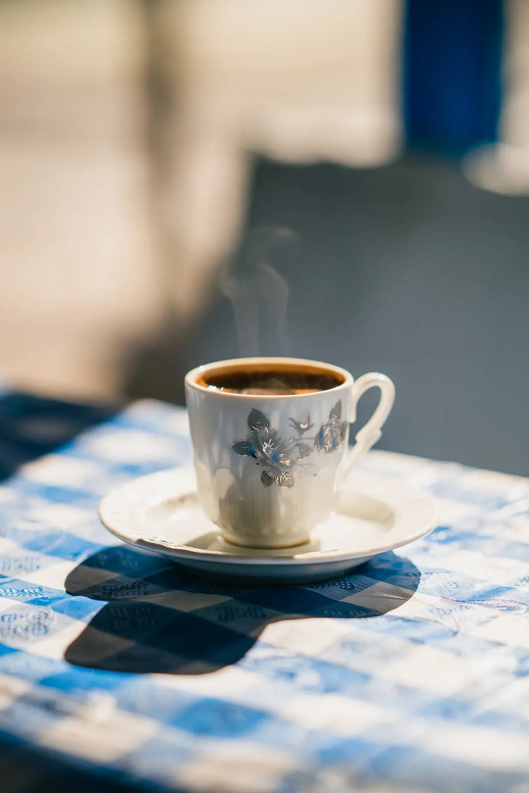 Steaming cup of Bean2Bean Espresso on a checkered tablecloth