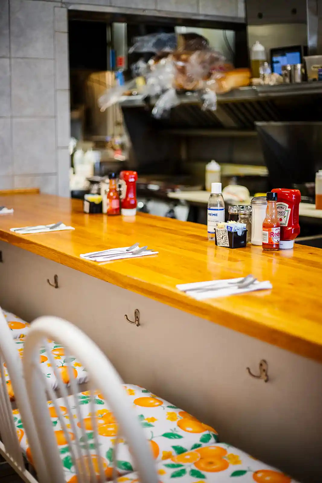 Bar counter with condiments and a blurred kitchen in the background