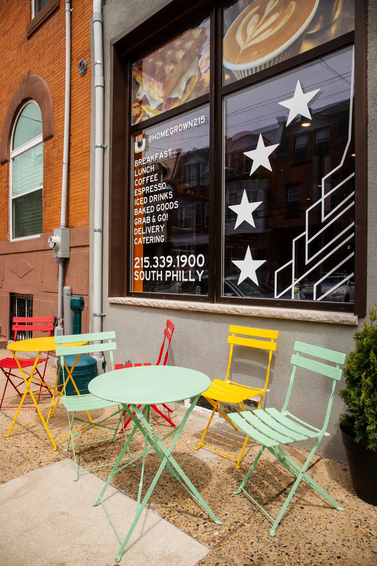 Colorful outdoor seating area in front of a coffee shop with a window display.