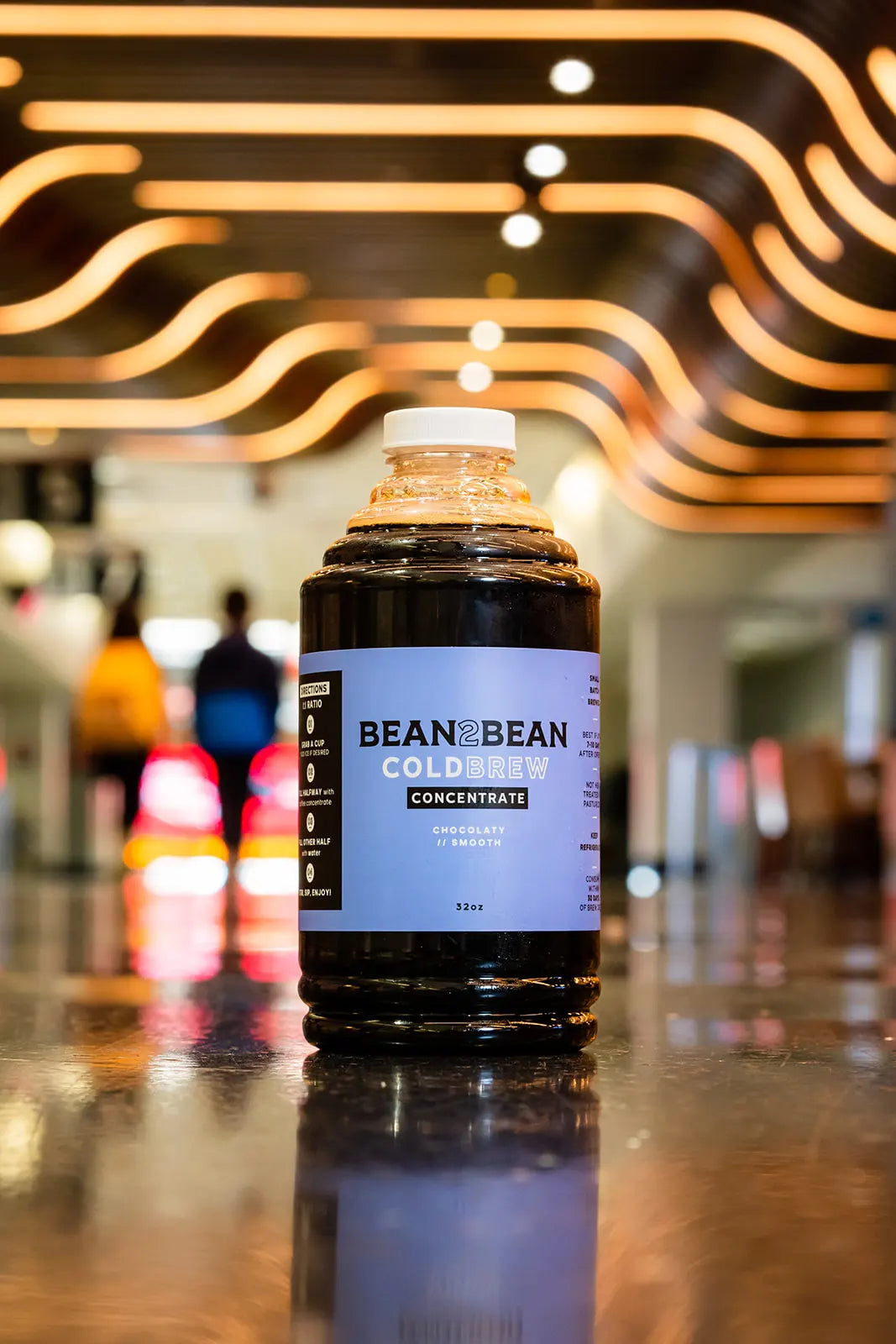 Bottle of Bean & Bean Cold Brew Concentrate on a reflective surface with blurred background