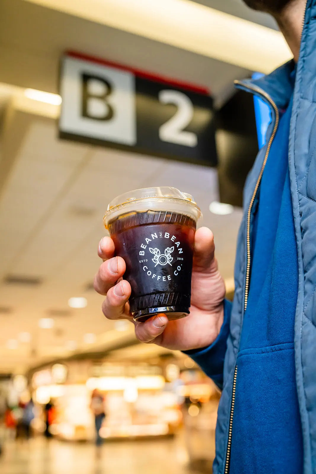 Person holding a Bean2Bean Coffee Co Cold Brew in an PHL International Airport
