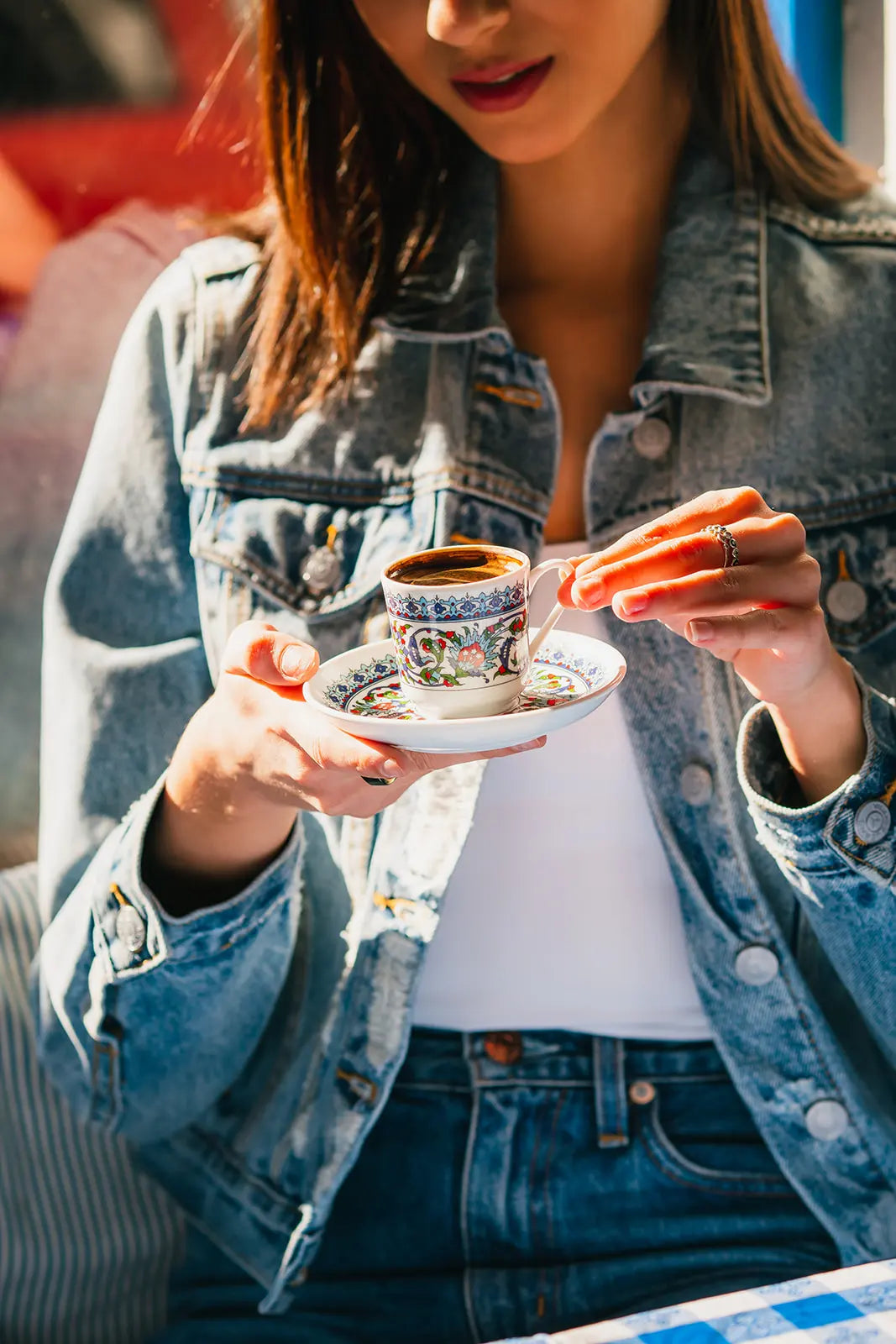 Woman holding a small cup of Bean2Bean coffee turkish style outdoors