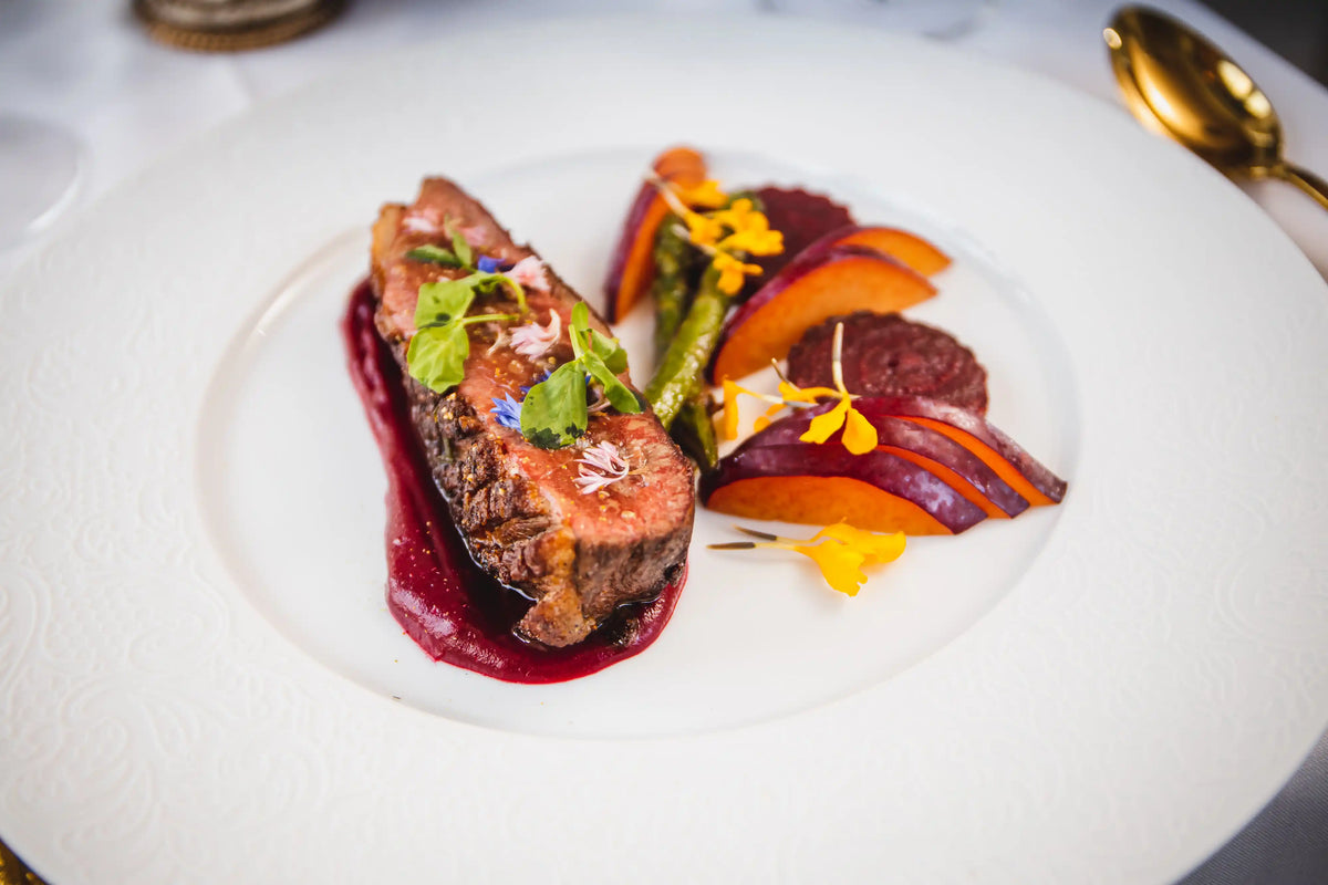 Delicate dish with a piece of meat and vegetables on a white plate