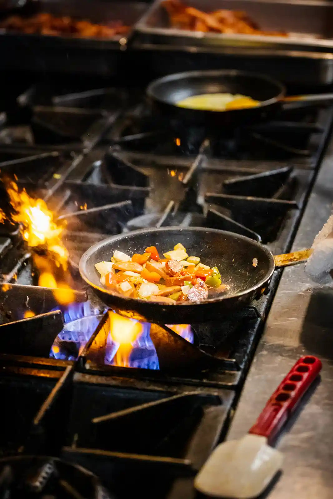 Frying pan with food on a gas stove with flames