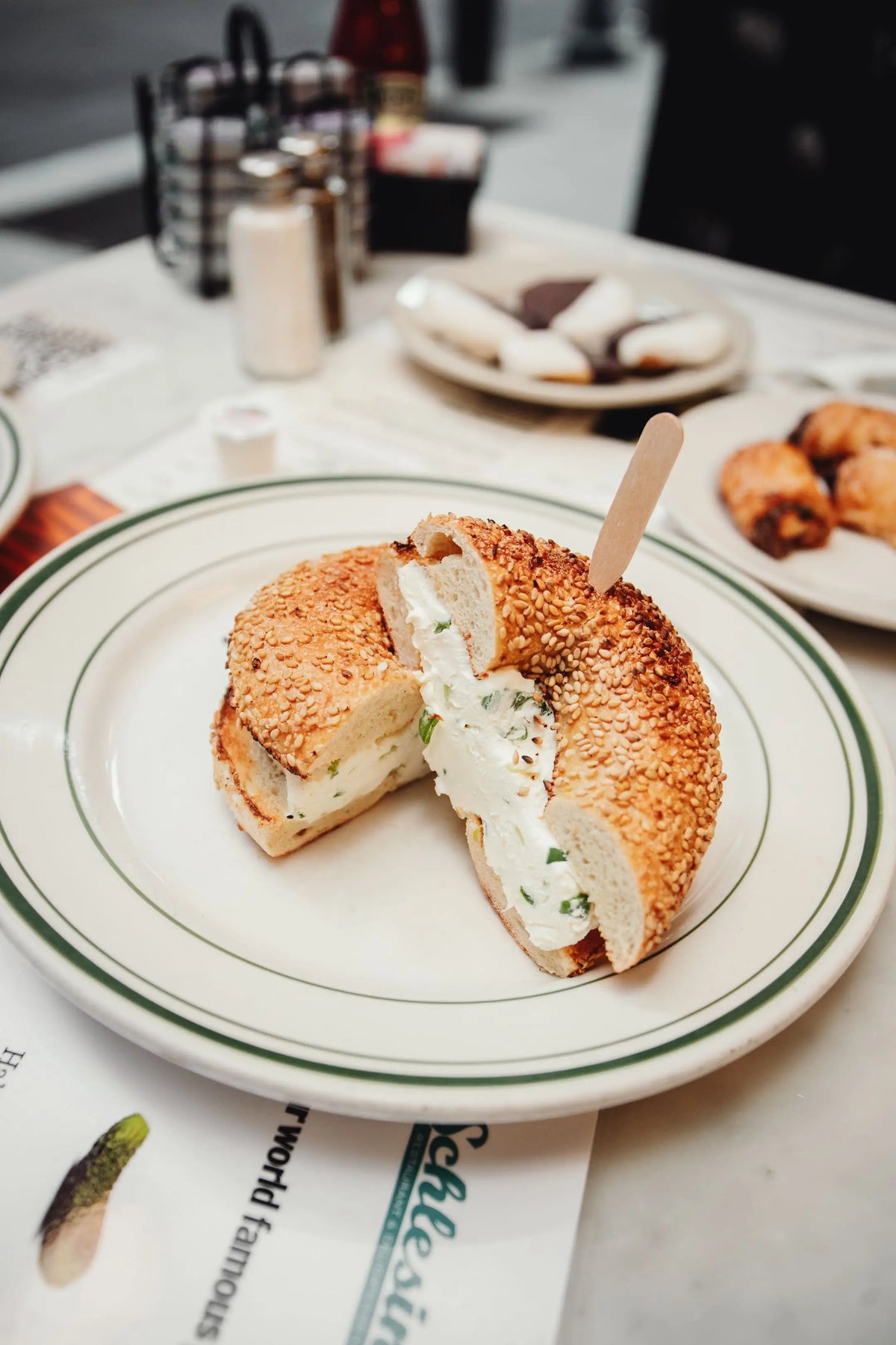 Sesame Bagel with cream cheese on a plate with a blurred background