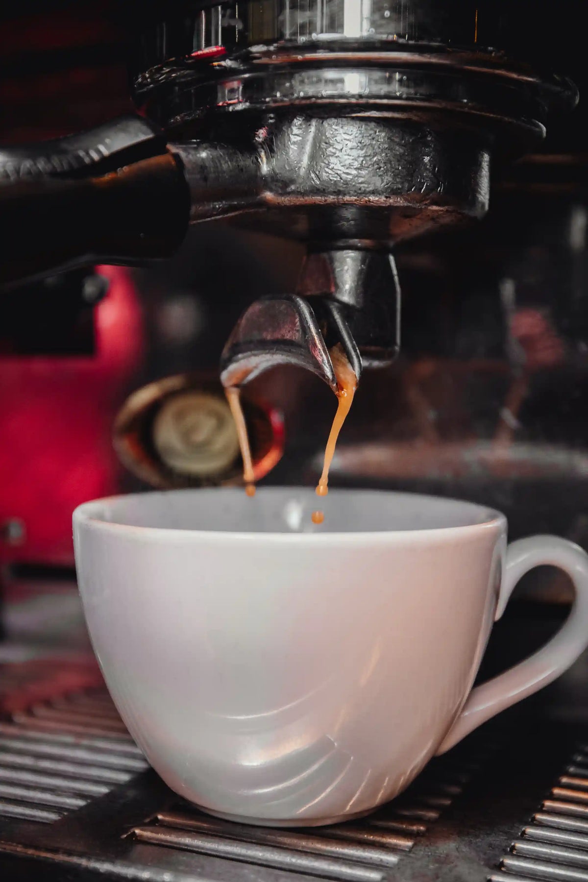 Bean2Bean Espresso being poured into a white cup from a espresso machine.