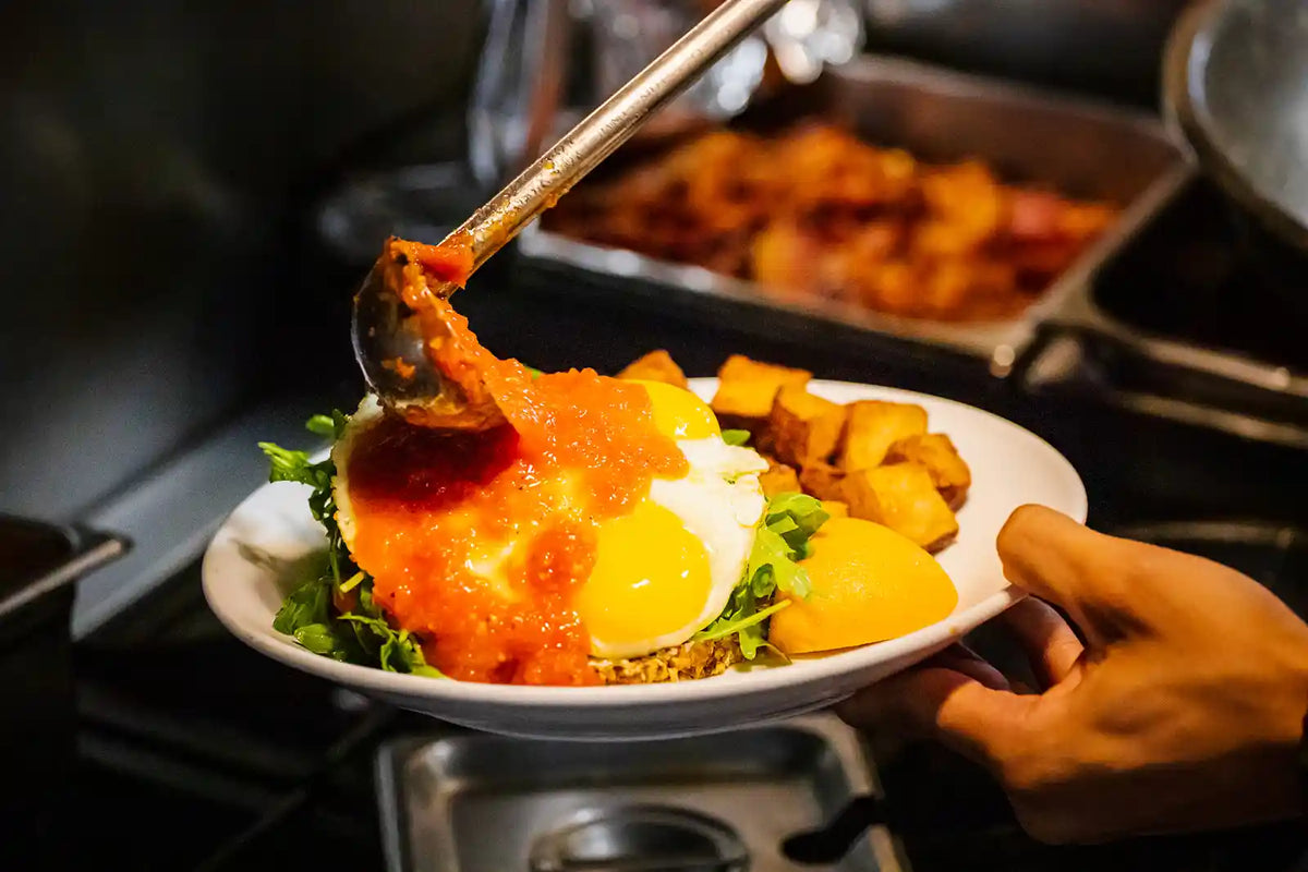 Plate of food with a spoonful being lifted, set against a kitchen background.