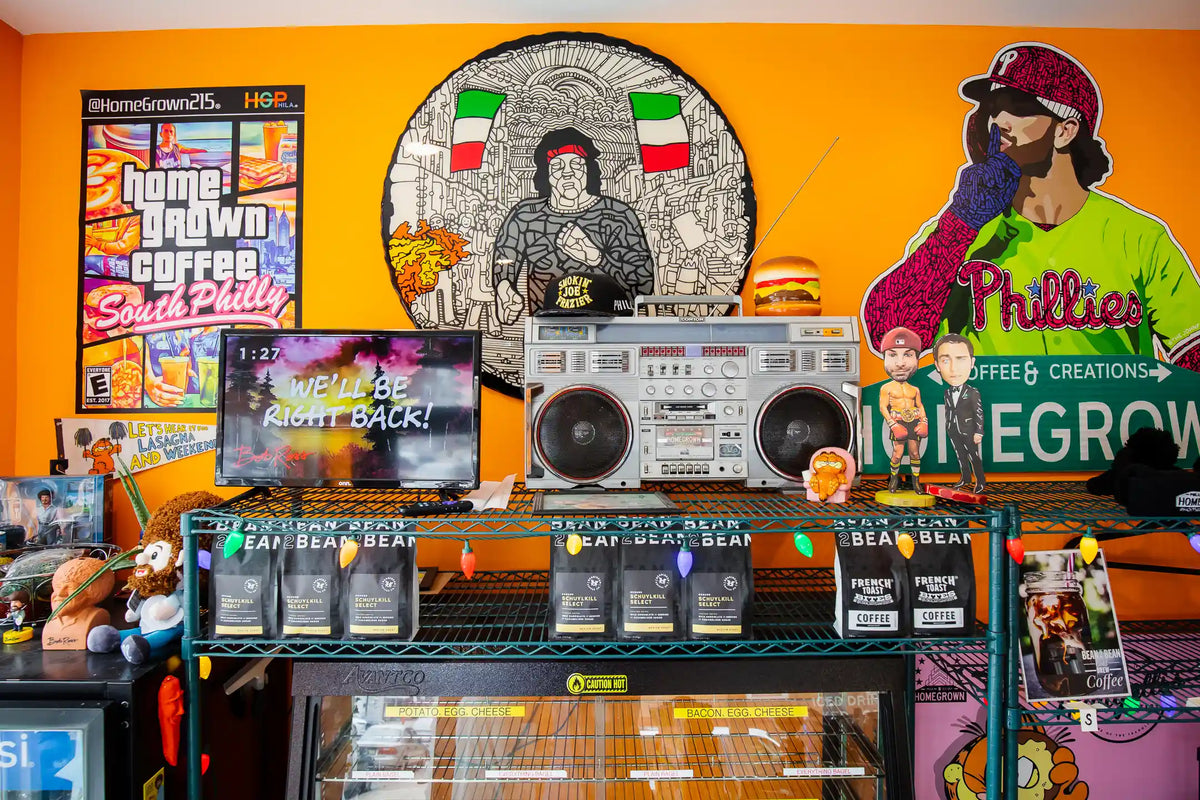 Display of coffee products and branded merchandise with a colorful mural in the background.