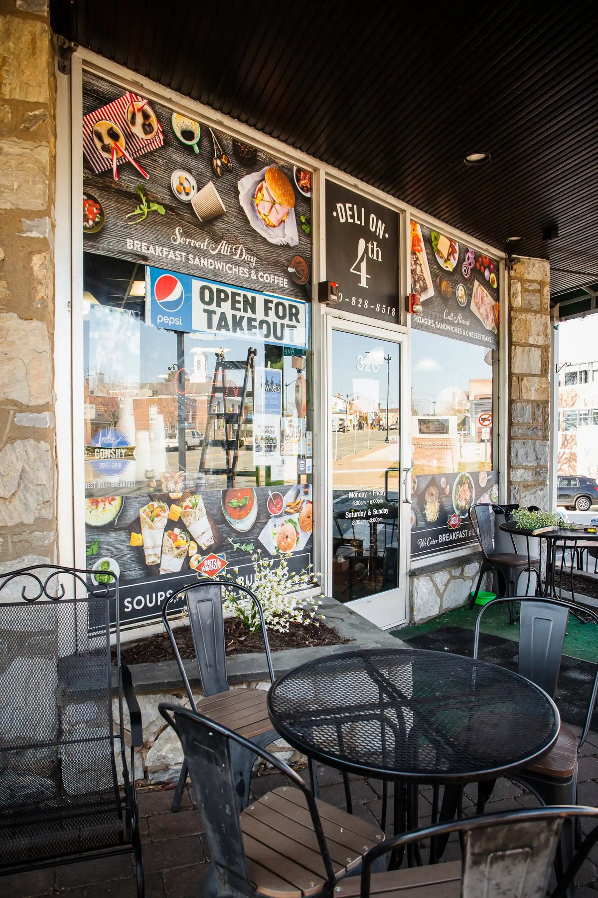 Deli on 4th storefront windows with small black metal table in front