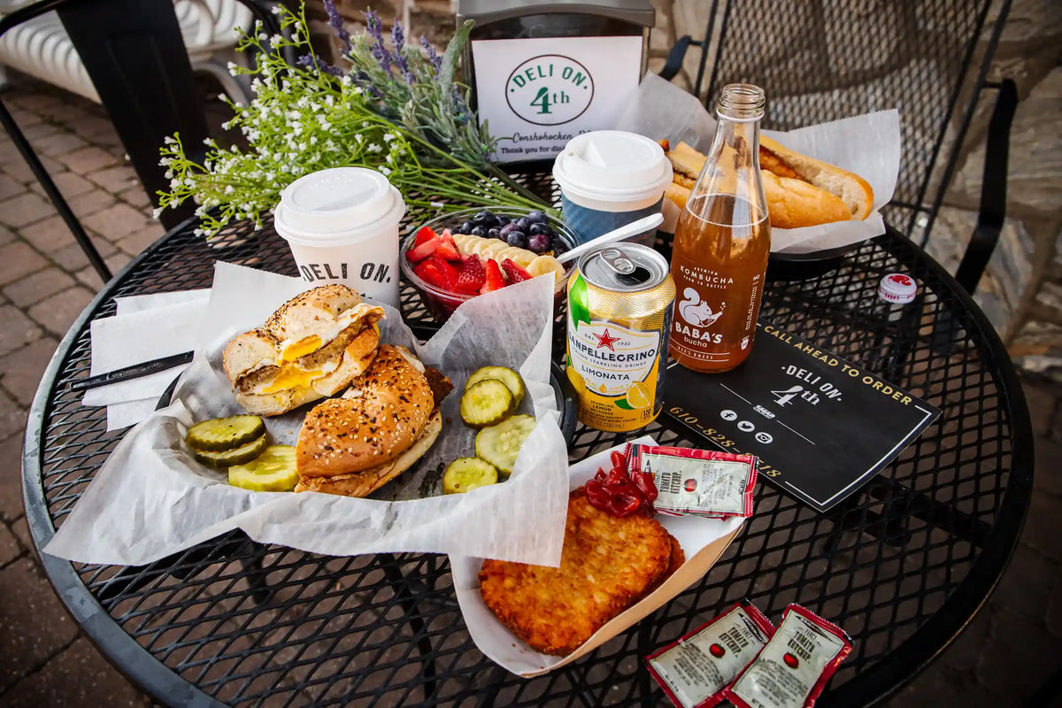 Table full of sparkling drinks, Bean2Bean coffee's, fruit, and plates of food