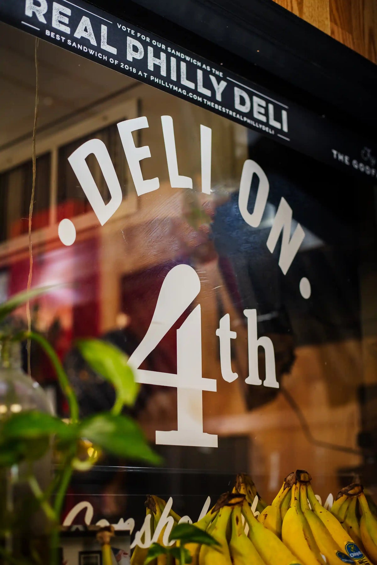 "Deli on 4th" decal in white on storefront window
