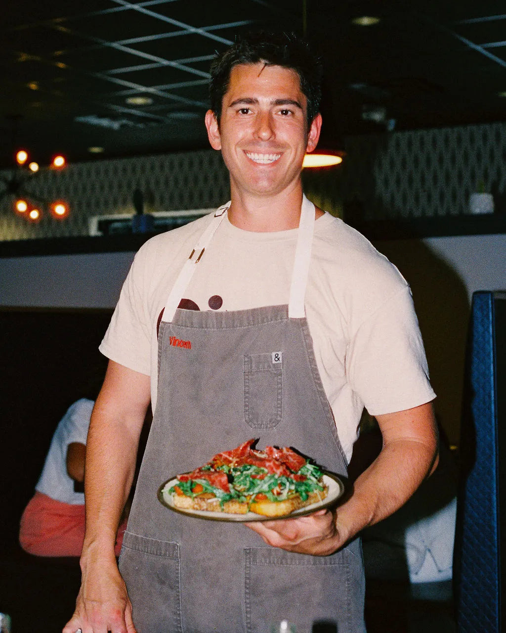 Man holding a pizza in a casual setting
