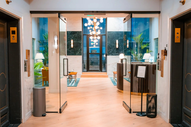 Modern building lobby with glass doors leading to a outdoor balcony area