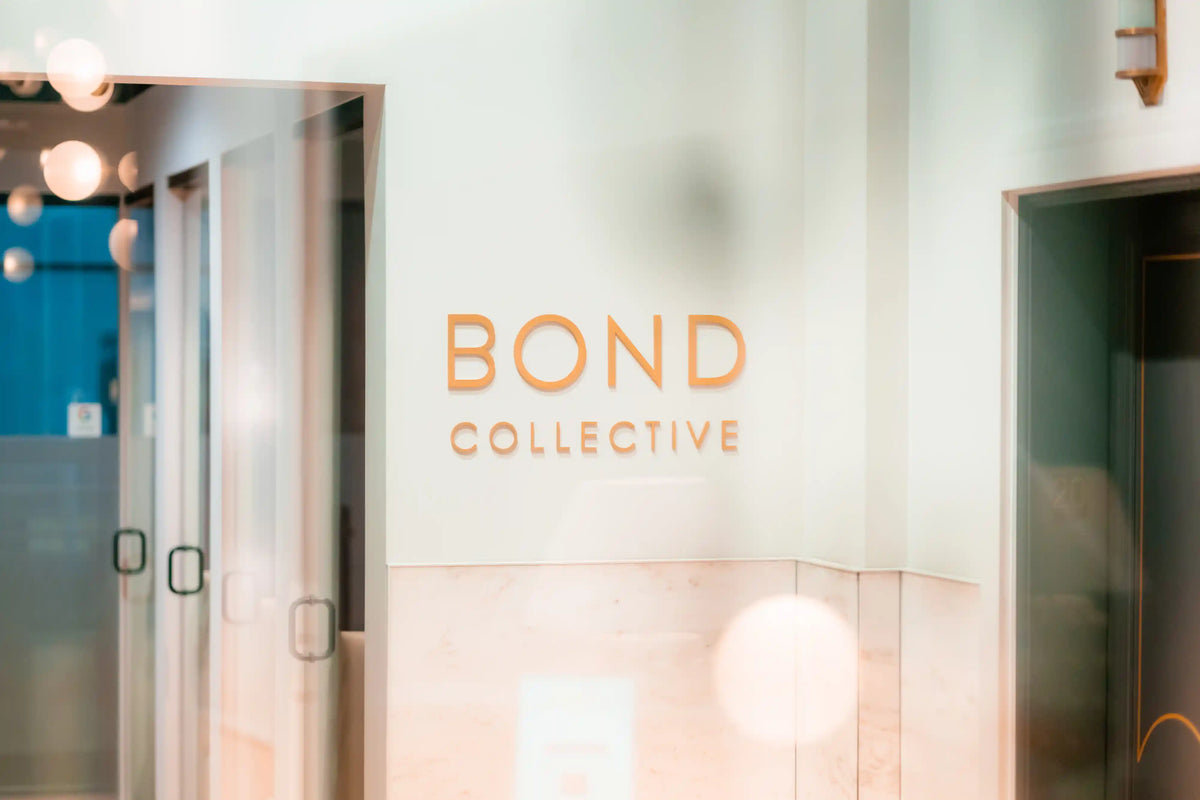 Entrance to a building with 'Bond Collective' branding on a glass door.