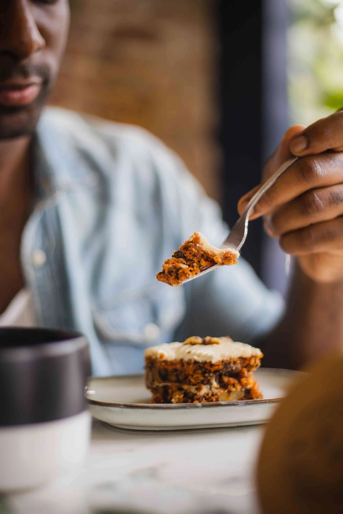 Person Eating carrot cake with fork