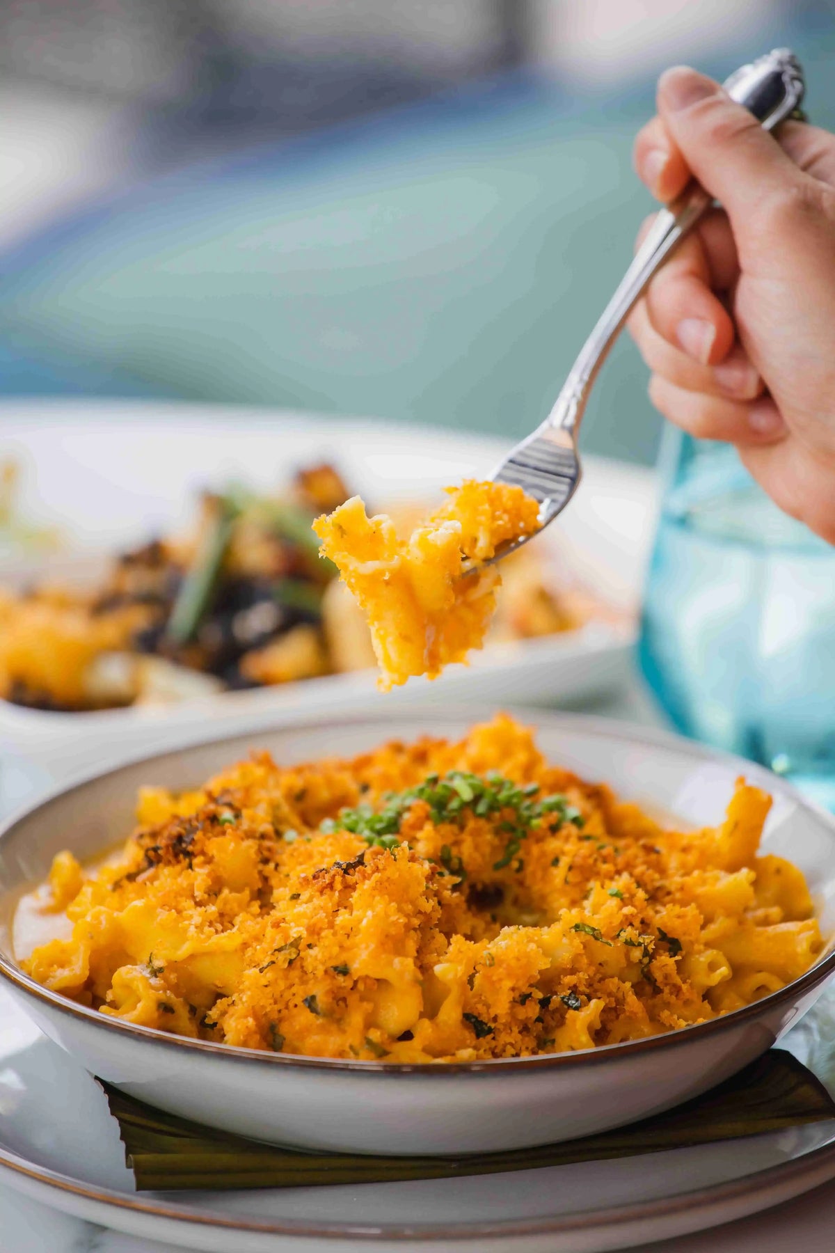 Person eating breadcrumb crusted homestyle mac and cheese with a fork