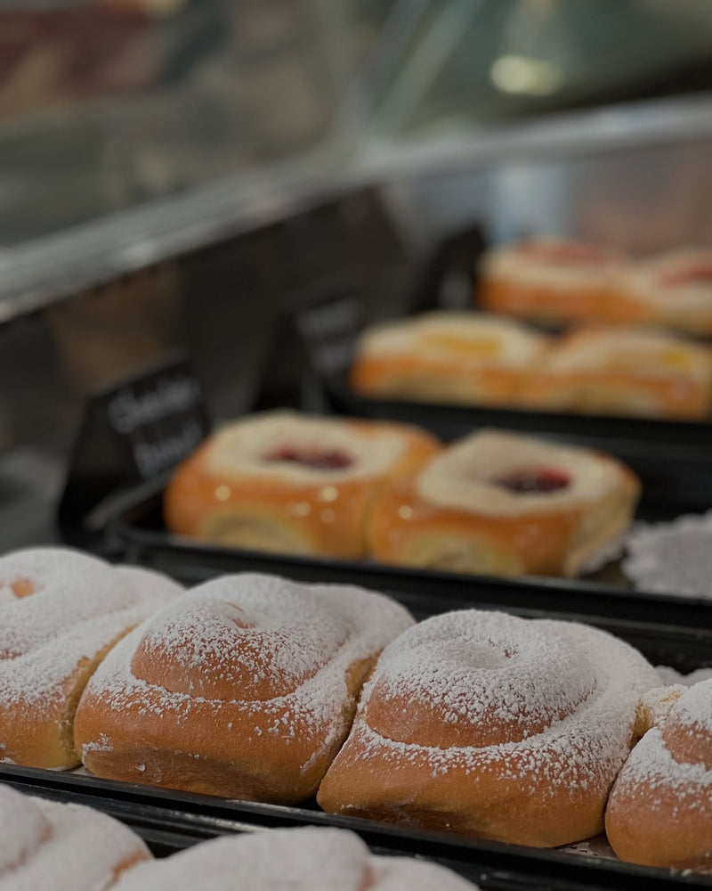 Pastries with powdered sugar on a tray, blurred background