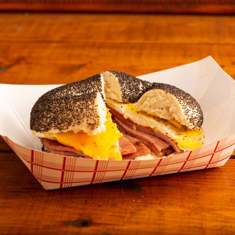 Submarine sandwich with poppy seed bagel on a wooden table