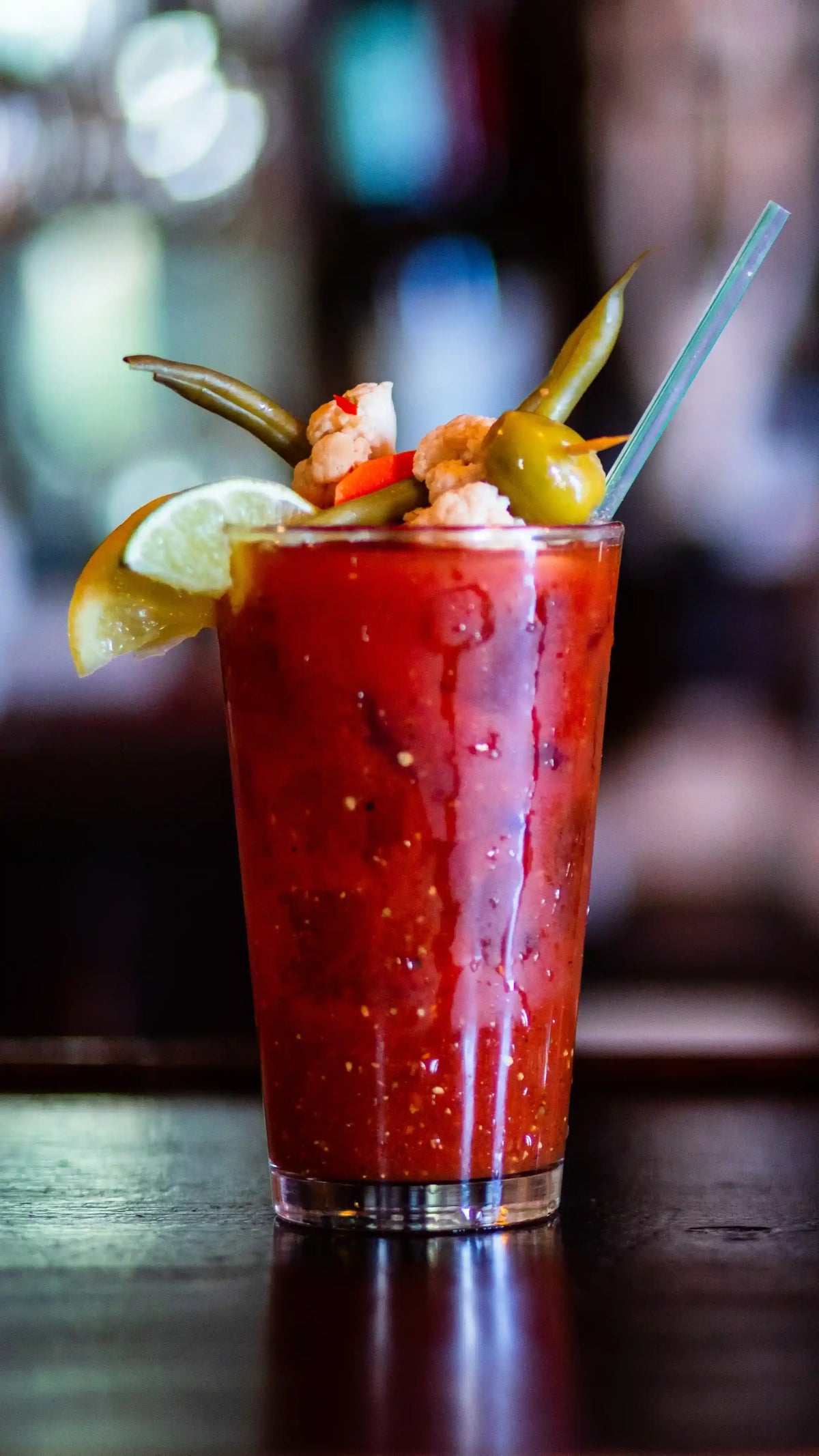Bloody mary cocktail with garnishes on a bar counter