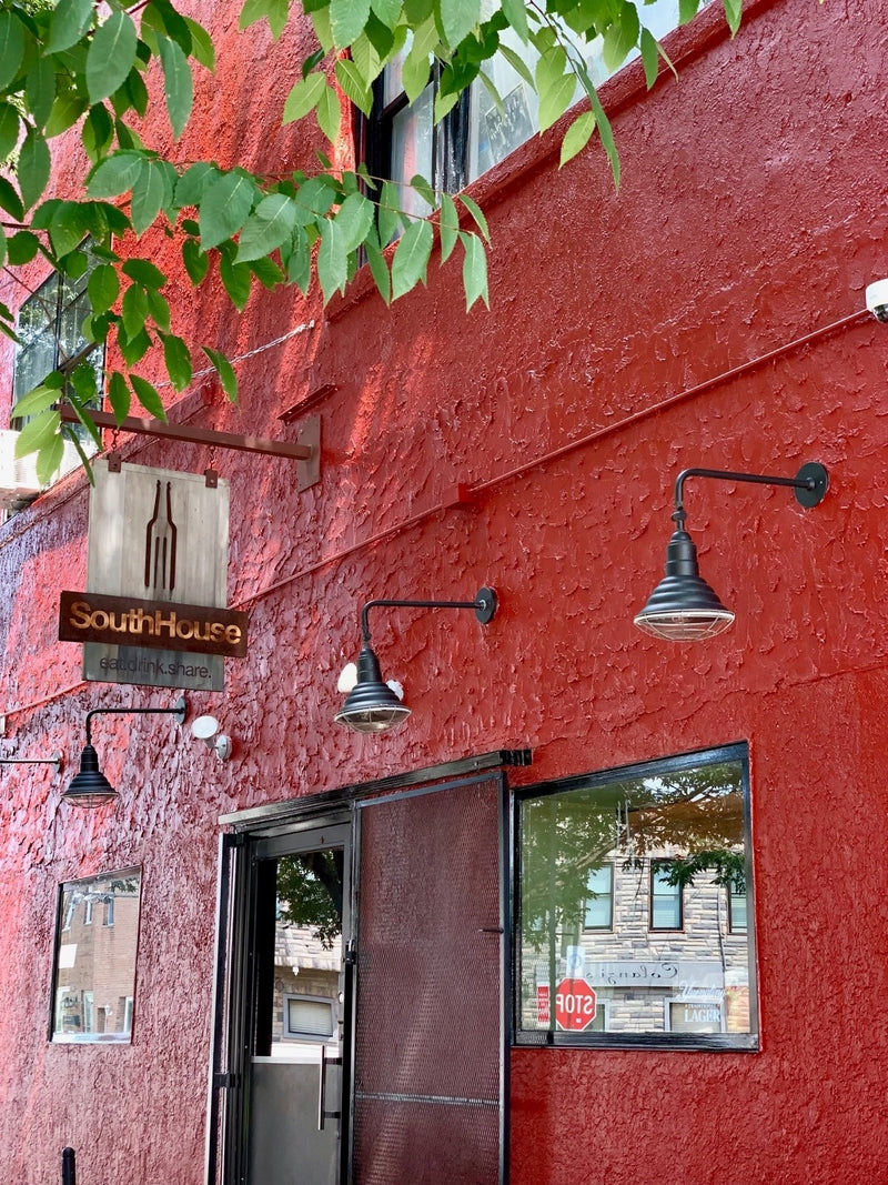 Red stucco building with 'South House' sign and street light