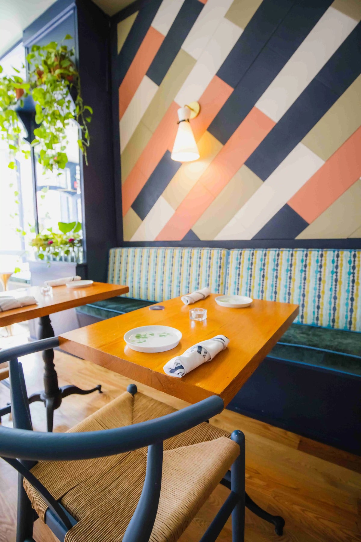 wooden table with chair and booth and colorful accent wall at Fitz on 4th