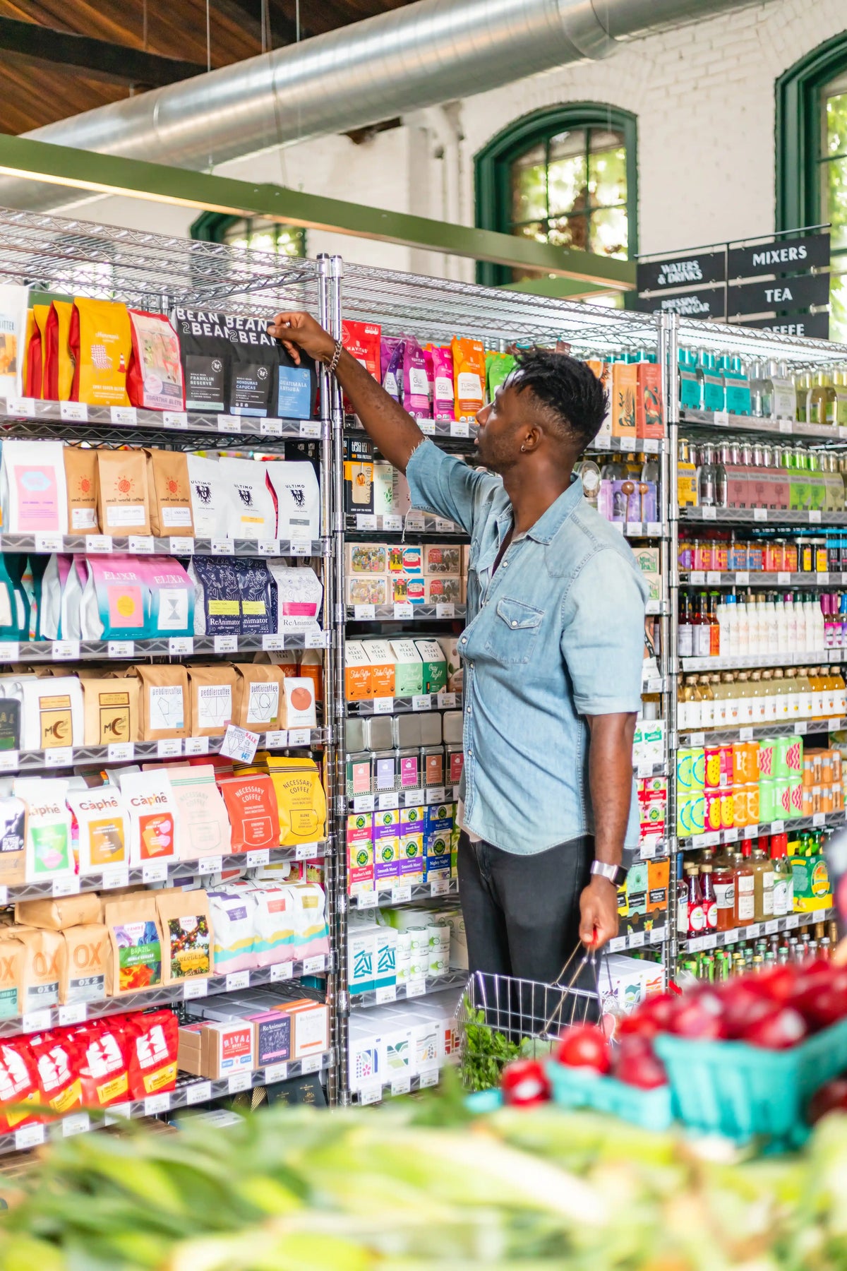 Person shopping in a grocery store aisle with shelves stocked with products.