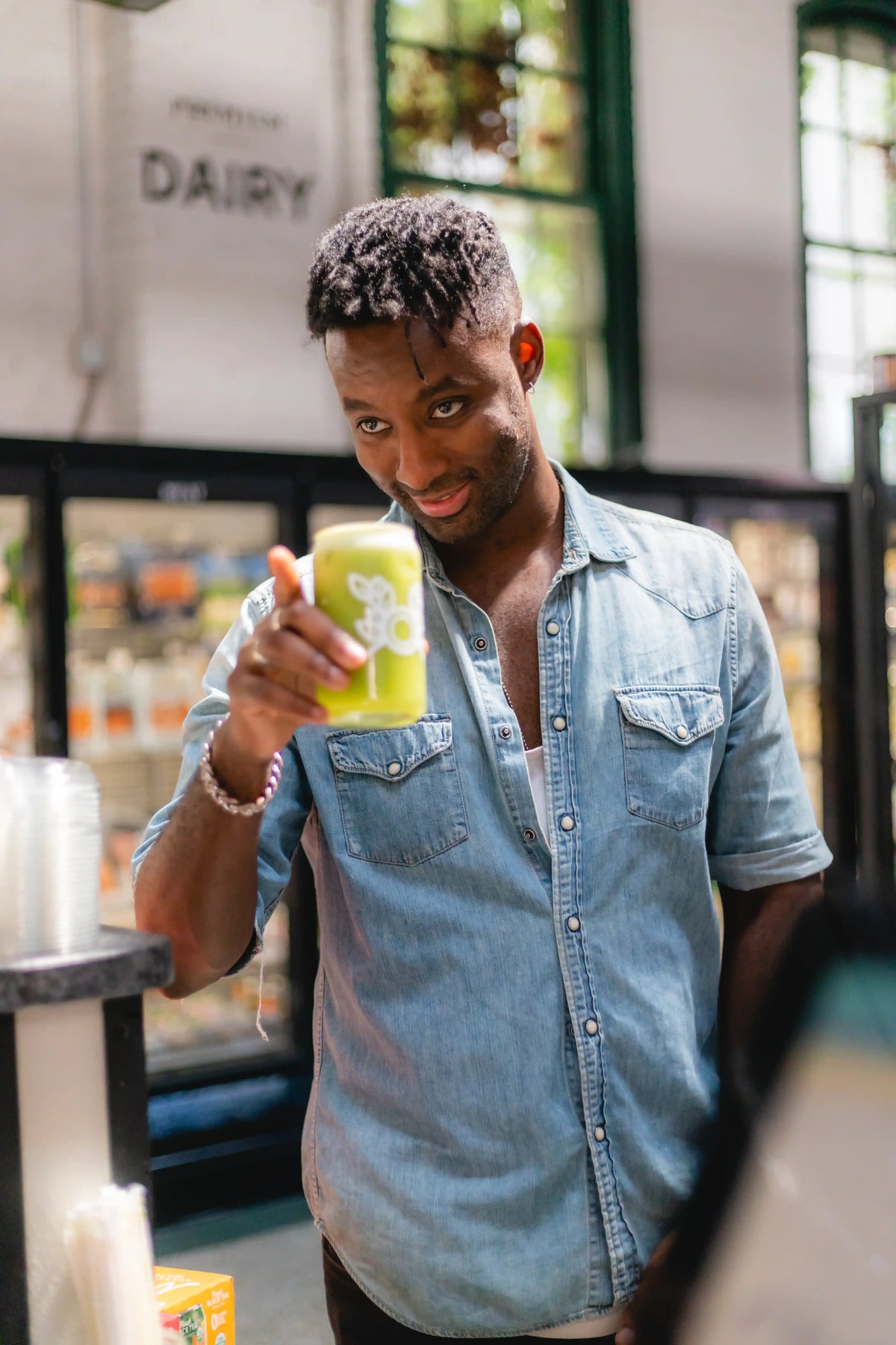 Man holding a green smoothie in Riverwards grocery store