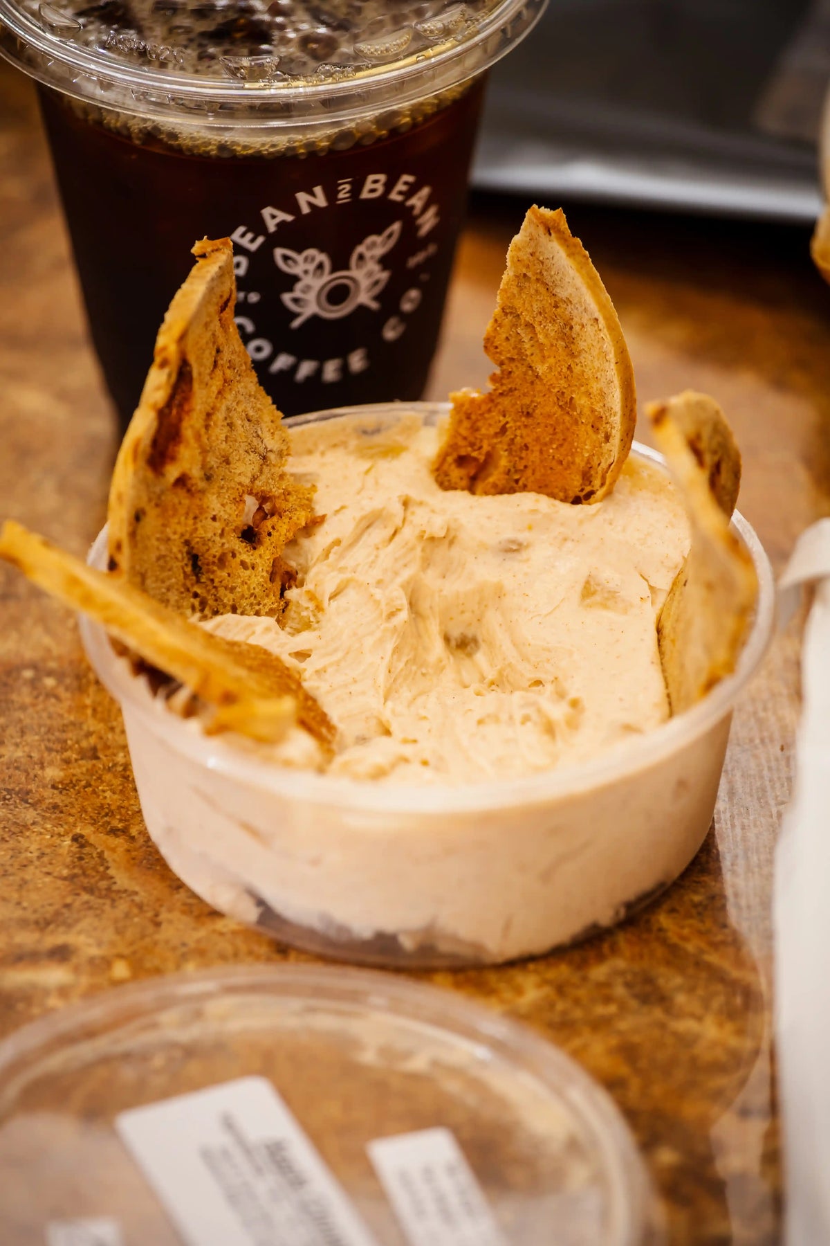 Ice cream with cookies and a drink labeled 'Can & Bean' on a wooden surface