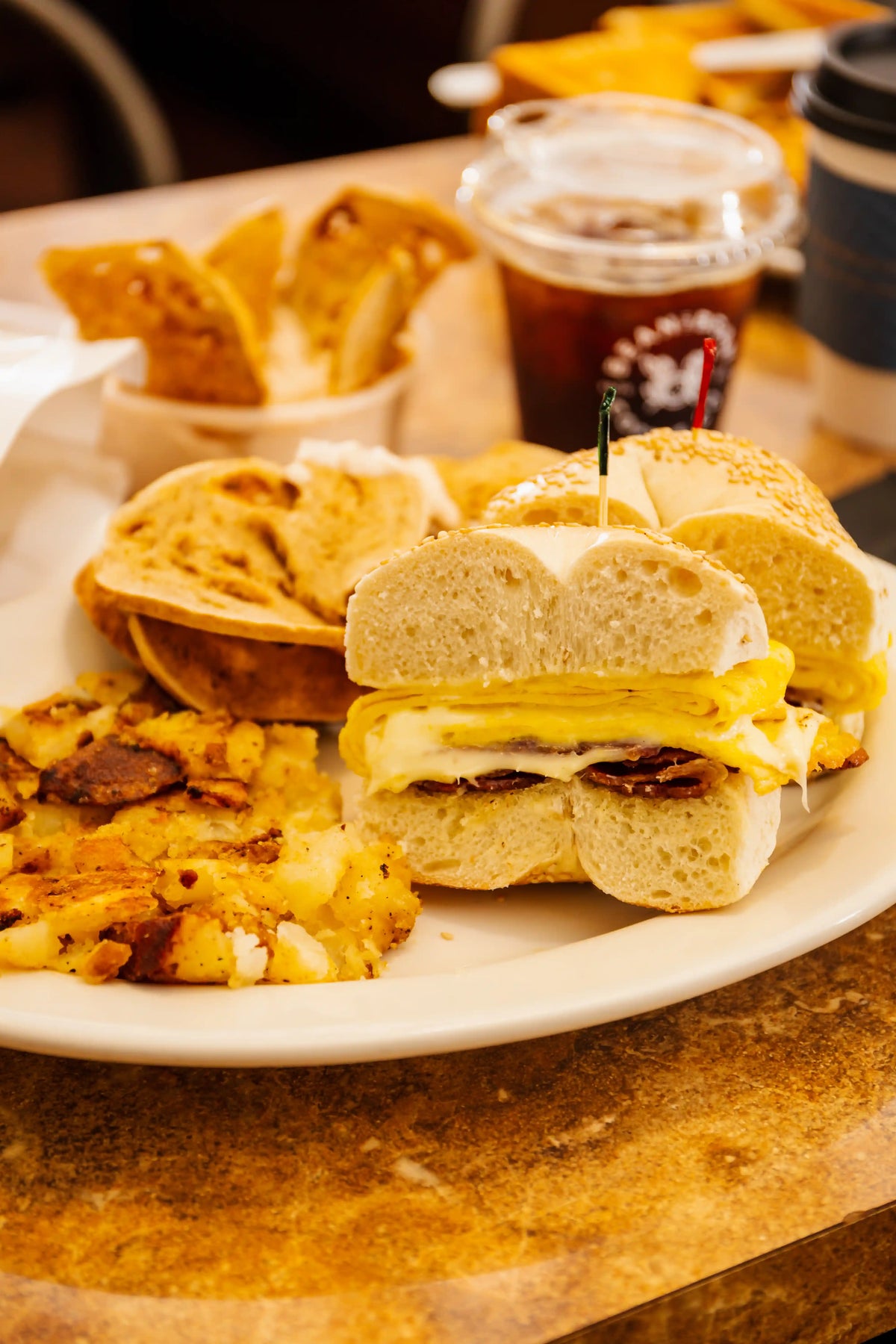 Breakfast plate with sandwiches, eggs, and coffee on a wooden table.