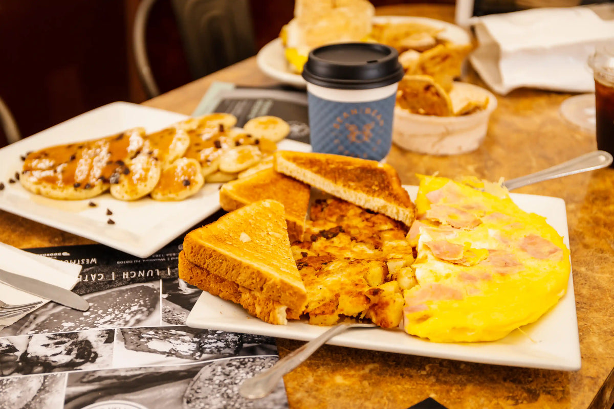 Breakfast spread with omelette, toast, and coffee on a table.