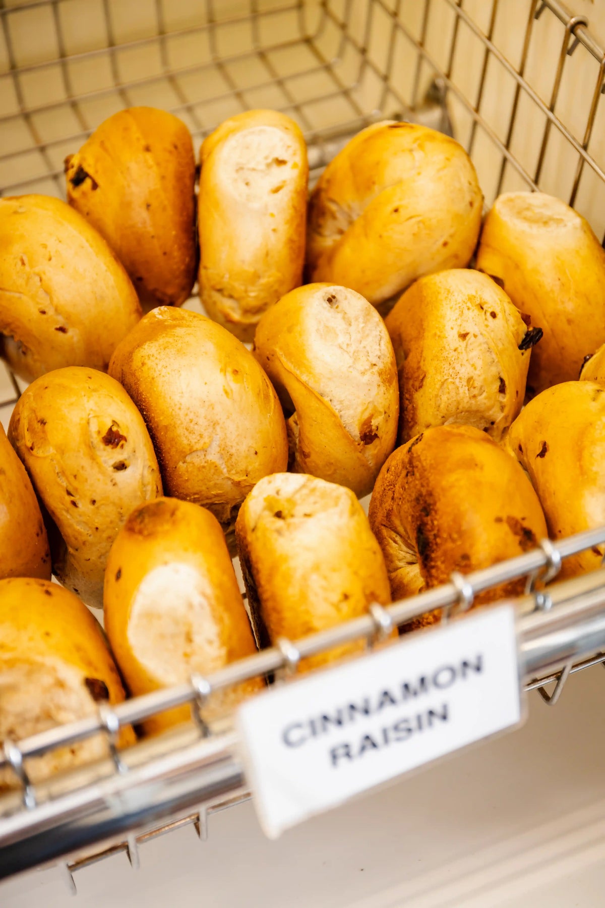 Cinnamon raisin rolls in a bakery display case with a label.