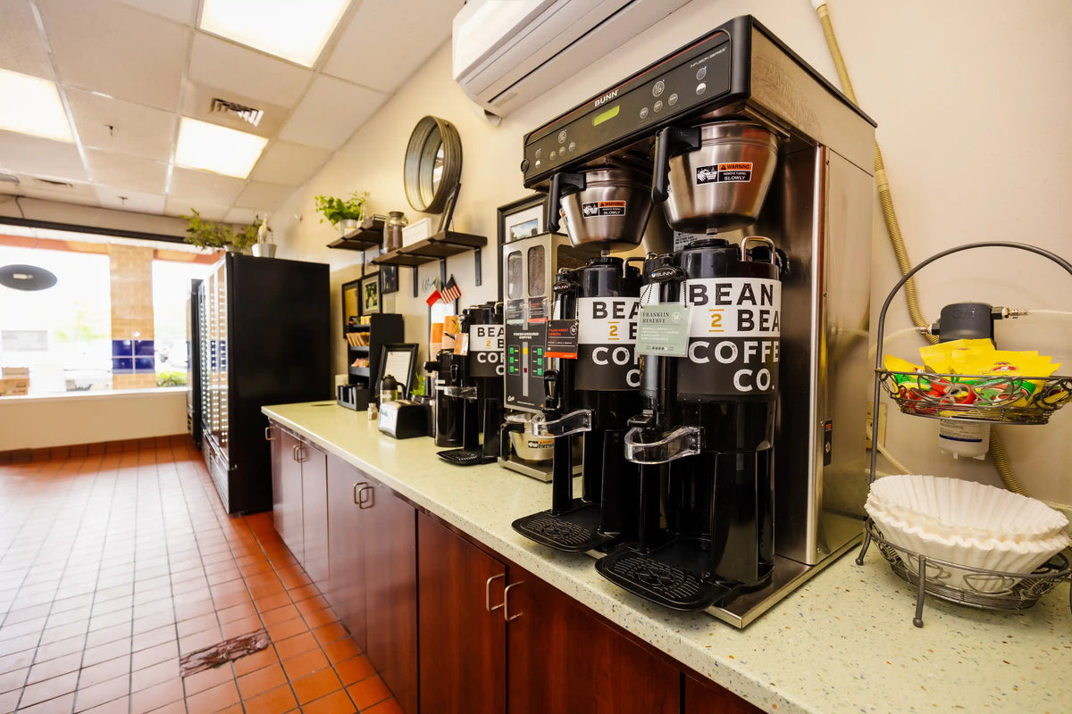 Coffee dispensers on a counter in a convenience store setting