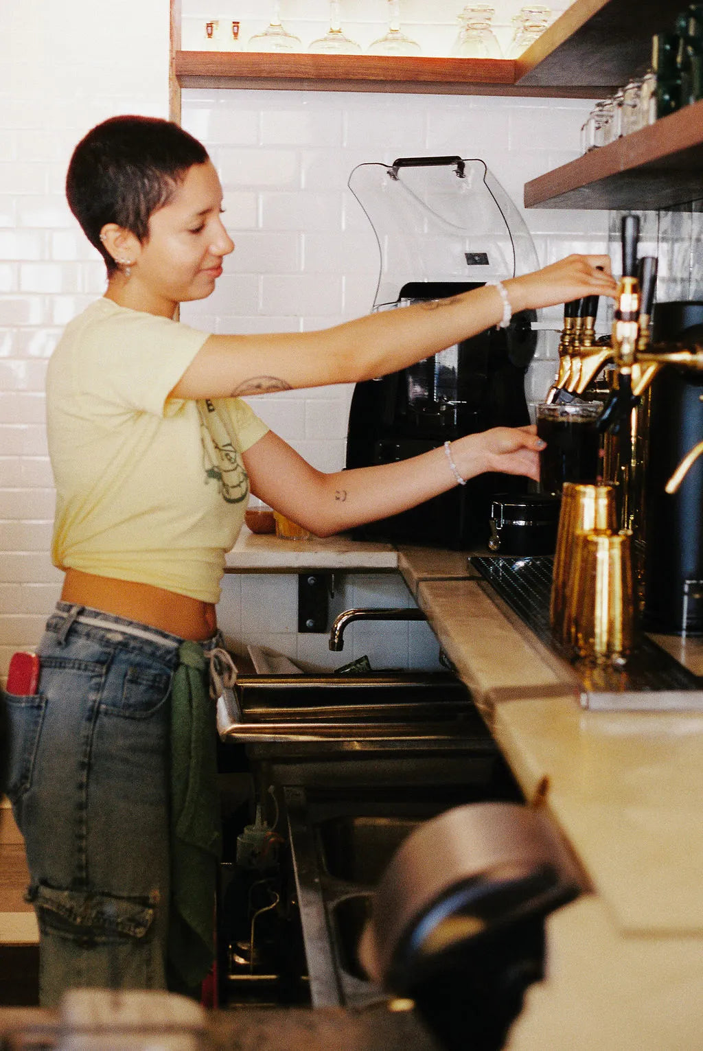 Person working at a coffee machine in a kitchen setting