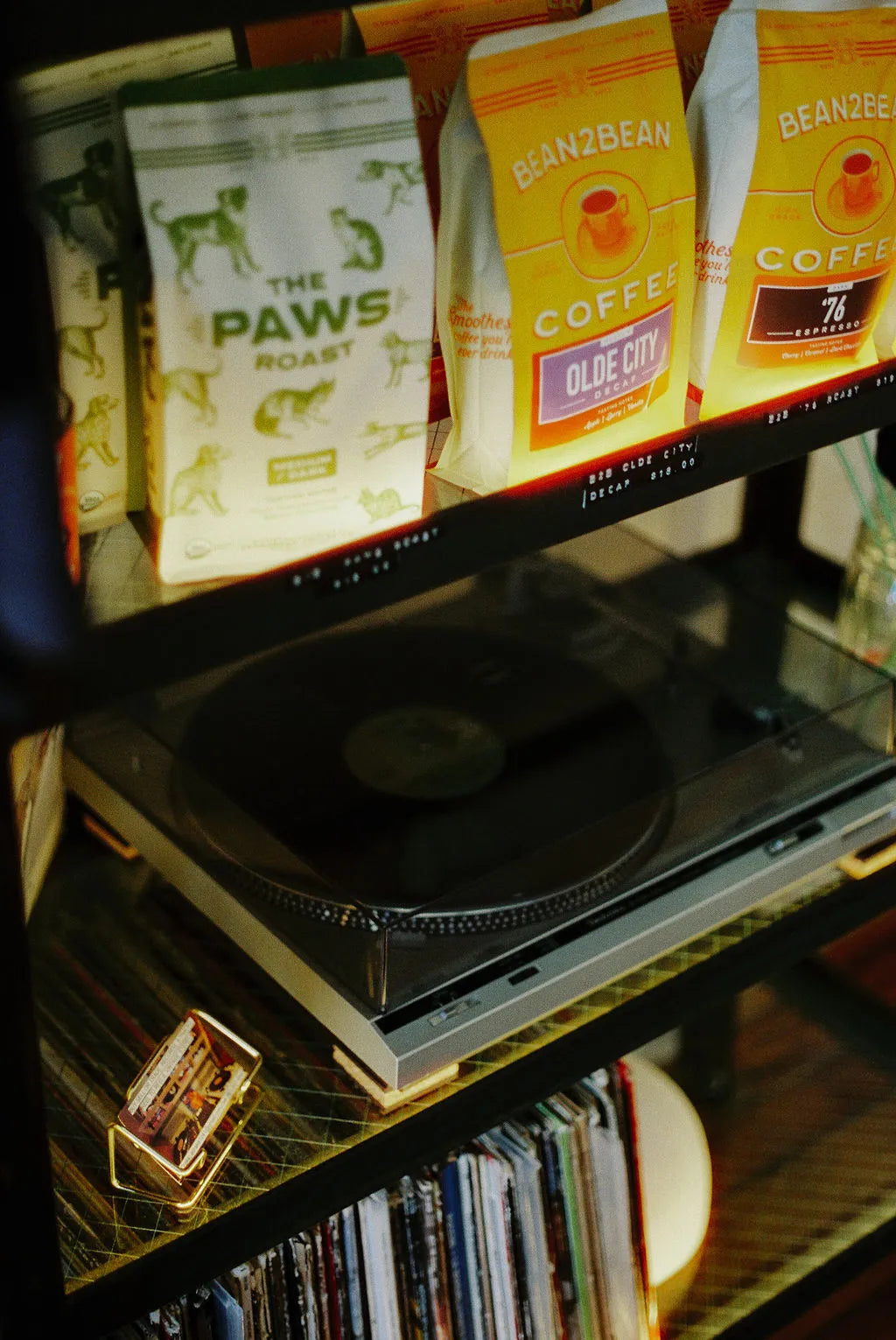 Record player on a shelf with Bean2Bean coffee bags and books in the background