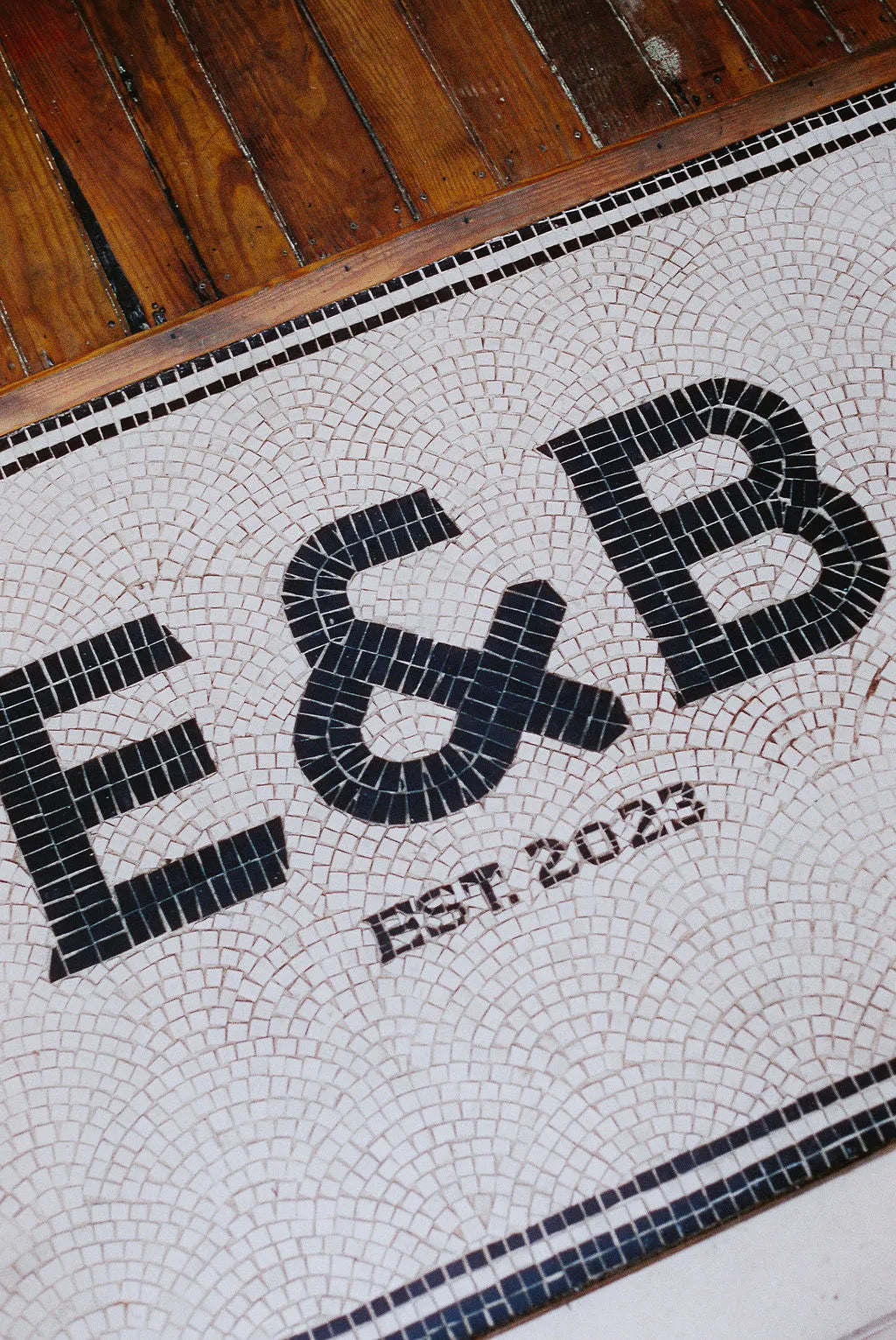 Mosaic floor with 'E&B' initials and 'EST. 2023'