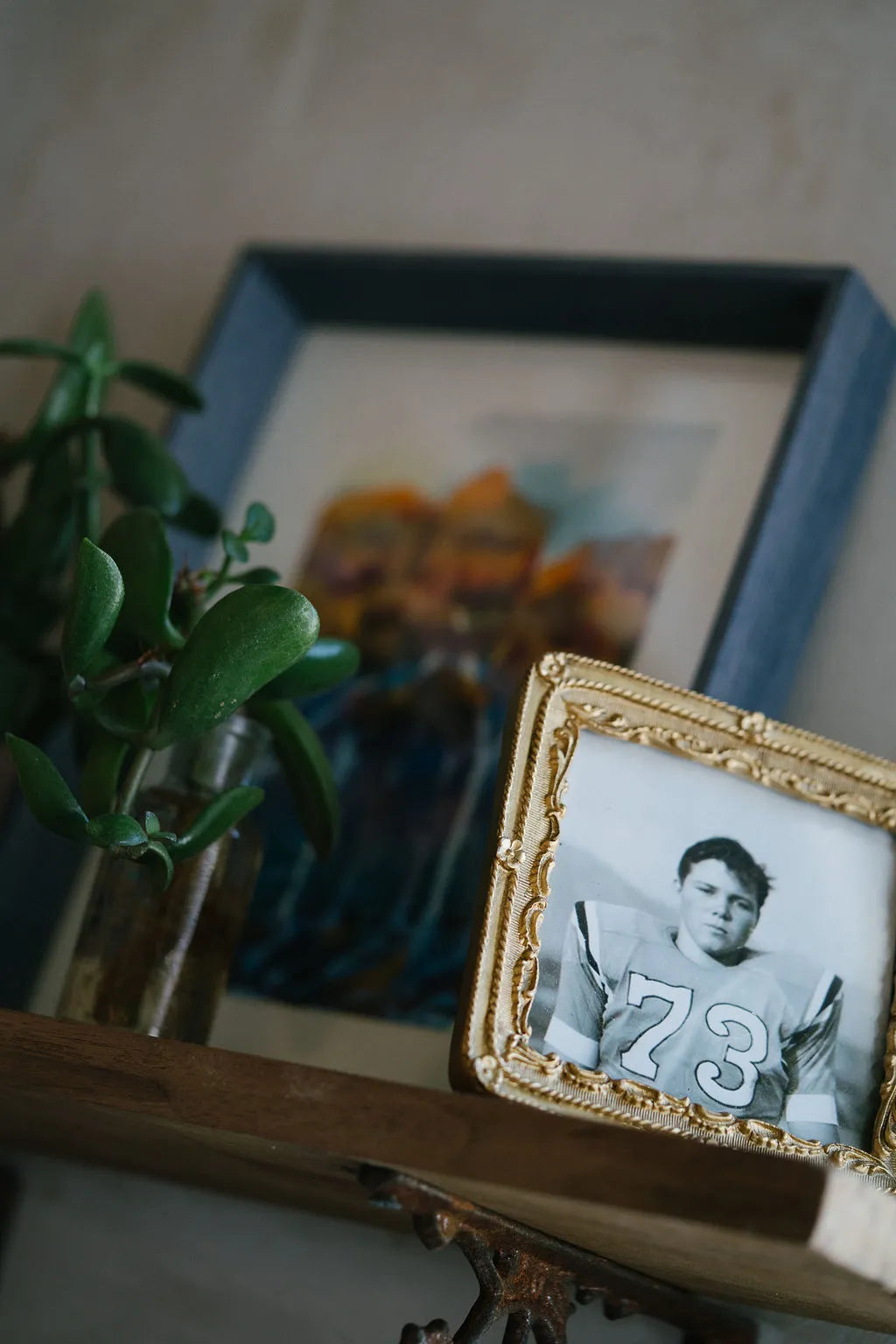 Small framed picture of a person with the number 73, placed on a surface with a blurred background.