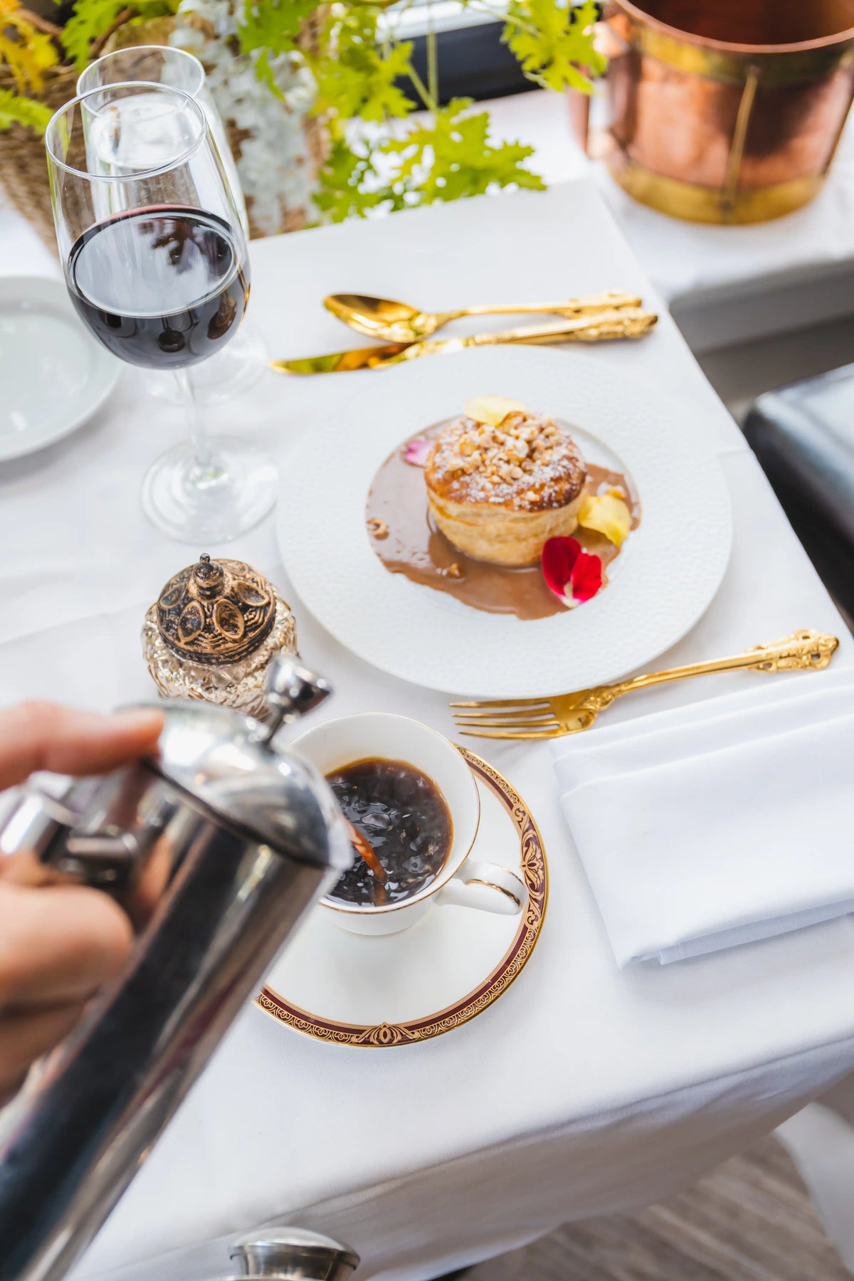 Dessert course with a tart, Bean2Bean coffee, and red wine on a white tablecloth.