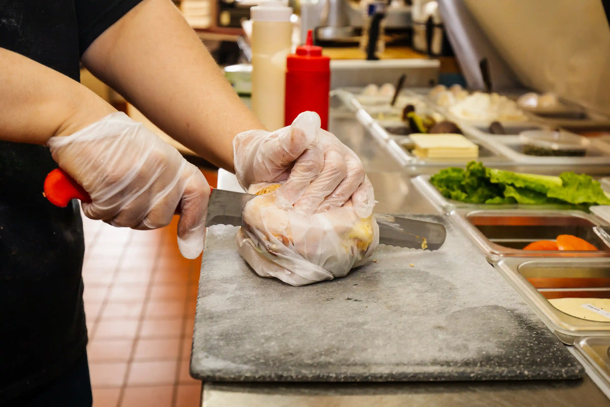 Person preparing food on a cutting board in a kitchen setting
